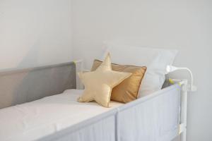 una cama con dos almohadas y una estrella en ella en OPORTO GUEST Villa do Ribeirinho, en Oporto