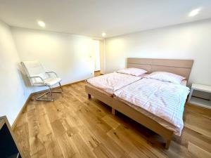 a bedroom with a bed and a chair in it at Ferienwohnung zur Hohe Str in Bad Langensalza
