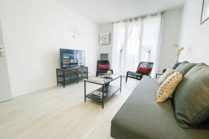 ein Wohnzimmer mit einem Sofa und einem TV in der Unterkunft The art of living in Grenoble #FV in Saint-Martin-dʼHères