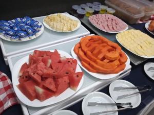 una mesa con platos de frutas y galletas y otros alimentos en Stop Inn Cristiano Machado, en Belo Horizonte