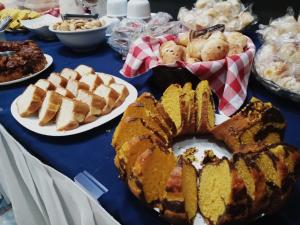 a table topped with plates of pastries and pies at Stop Inn Cristiano Machado in Belo Horizonte