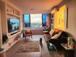 a living room with a couch and a tv at Piso 19 - Acogedor apartamento de 3 Recámaras in Panama City
