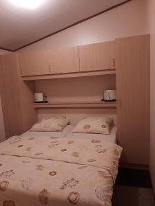 een kleine slaapkamer met een bed met 2 kussens bij Boszicht-Winterswijk in Winterswijk