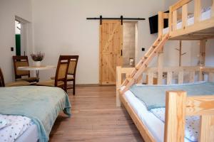 a bedroom with two bunk beds and a table at Miętowe Zacisze Zator in Laskowa