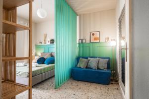 Zimmer mit einem Bett und einem blauen Sofa in der Unterkunft DomusFebo - Cipro Suites in Rom