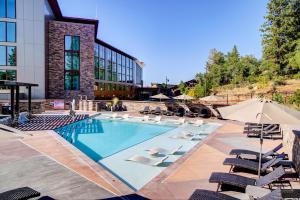 a pool with chairs and umbrellas next to a building at Red Hawk Resort & Casino in Placerville
