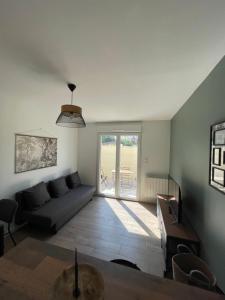 uma sala de estar com um sofá e uma mesa em Gîte La Sablière em Saint-Germain-lès-Arpajon