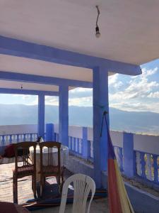 two chairs and a table on the roof of a house at Hostel Meharchen in Chefchaouen