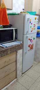 a kitchen with a white refrigerator and a microwave at A Home away from home in Ruaka