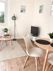 a living room with a table and a tv at La Liberté I Central I Parking gratuit in Romans-sur-Isère +2 photos