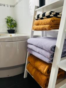 una pila de toallas en un estante del baño en The Heather Dew, en Portstewart