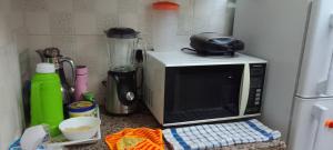 a kitchen counter with a microwave and a blender at A Home away from home in Ruaka