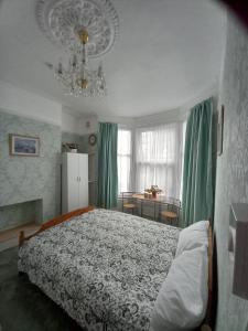 1 dormitorio con cama y lámpara de araña en Mari London room for holiday, en Ilford