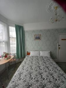 1 dormitorio con cama, mesa y ventana en Mari London room for holiday, en Ilford
