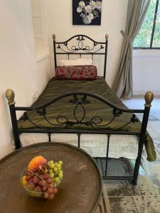 a table with a bowl of fruit on a bed at Autentic villa at the sea coast in Haifa