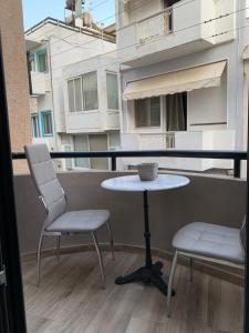 a table and two chairs on a balcony at Central & Beautiful in Sitia