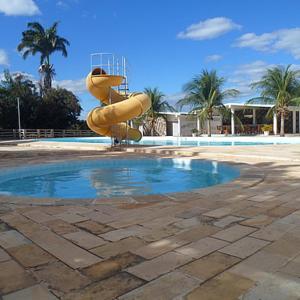 un toboggan gonflable jaune à côté d'une piscine dans l'établissement Hotel das Palmeiras, à Serra Talhada