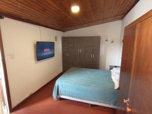 1 dormitorio con 1 cama y TV en la pared en Vista al mar playas del Faro en Mar del Plata