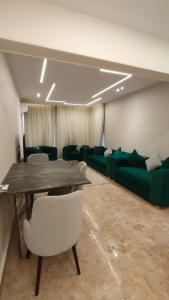 a conference room with a table and green couch at شقه فاخره بمدينه نصر امام سيتى ستارز in Cairo