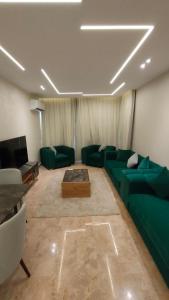 a living room with a green couch and a tv at شقه فاخره بمدينه نصر امام سيتى ستارز in Cairo