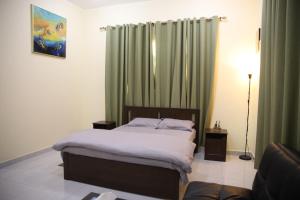 Luxury private Studio apartment close to Airport في أبوظبي: غرفة نوم بسرير وستارة خضراء