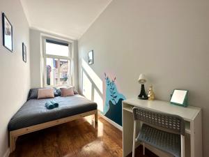 a small bedroom with a bed and a table at MMRent Botanic Room in Gdańsk