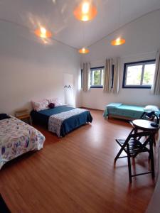 ein Schlafzimmer mit 2 Betten und einem Tisch darin in der Unterkunft Casa nova com suítes amplas in Ouro Preto