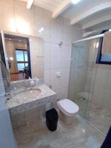 La salle de bains est pourvue de toilettes, d'un lavabo et d'une douche. dans l'établissement Casa nova com suítes amplas, à Ouro Preto