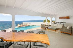 un soggiorno con tavolo e vista sull'oceano di Puerta Al-Mar Villa a Simpson Bay