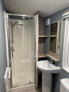 a bathroom with a shower and a sink at Garden guest house in Høvik