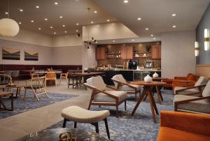 a lobby of a hotel with tables and chairs at Sheraton Grand Rapids Airport Hotel in Grand Rapids