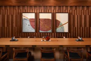 a table in a room with four pictures on the wall at Sheraton Grand Rapids Airport Hotel in Grand Rapids