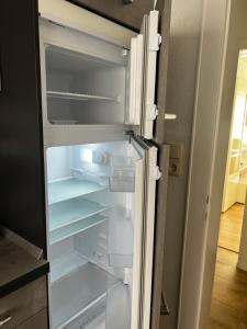 an empty refrigerator with its door open in a kitchen at Schönes Zuhause in Hildesheim