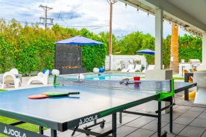 a ping pong table on a patio next to a pool at The Agave Oasis in Scottsdale