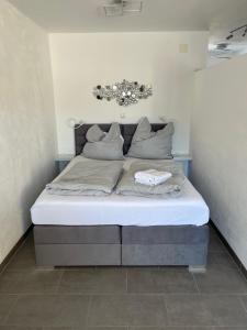 uma cama com lençóis brancos e almofadas num quarto em Kleiner Kristall inklusive MeineCard Plus em Willingen