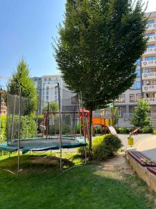 einen Spielplatz mit einem Baum und einem Trampolin in der Unterkunft Johannesburg Spacious Family apt w Free Parking and Playground in Sofia