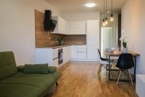 uma sala de estar e cozinha com um sofá e uma mesa em Apartment LaSiesta II em Ptuj
