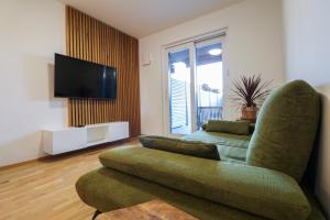 uma sala de estar com um sofá e uma televisão de ecrã plano em Apartment LaSiesta II em Ptuj