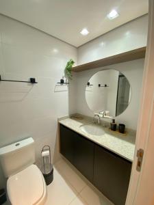 uma casa de banho com um WC, um lavatório e um espelho. em loft luxuoso Home & Lifestyle Ibirapuera. N.946 em São Paulo