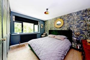 1 dormitorio con cama y pared azul en Stunning, high end country house, en Nether Whitacre