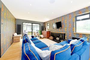 a living room with a blue couch and a fireplace at Stunning, high end country house in Nether Whitacre