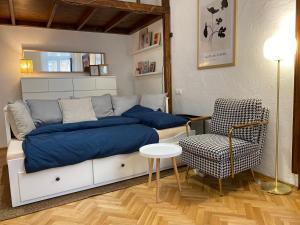 a bedroom with a bed with blue sheets and a chair at Cozy & stylish city centre flat in Budapest
