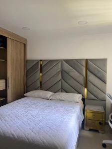 1 dormitorio con 1 cama grande y cabecero de madera en Habitación en apartamento Robledo-Medellin, en Medellín