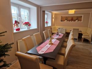 uma sala de jantar com uma mesa longa e cadeiras em Hotel Garni Haus Sonneneck em Thale