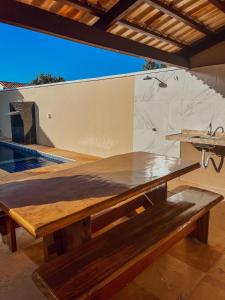 einen großen Holztisch in einem Zimmer mit einer Theke in der Unterkunft Chill House Praia do Preá-CE in Prea