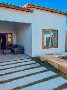 ein weißes Haus mit einem Sofa und einem Fenster in der Unterkunft Chill House Praia do Preá-CE in Prea