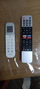 dos mandos a distancia sentados sobre una mesa en Departamento Familiar con estacionamiento incluido, en Bahía Blanca