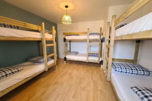 a room with four bunk beds and a wooden floor at La Graviere - 28pers - swimming pool pétanque billiards in Fontenay-Trésigny