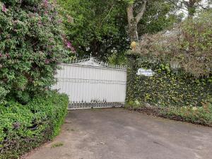 a white fence next to a driveway with flowers at ROSA CORTIANA Escalera in São Gabriel