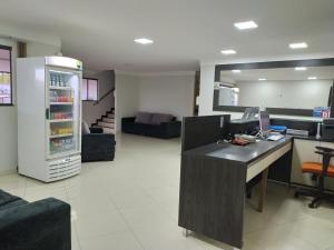 eine Küche und ein Wohnzimmer mit einem Schreibtisch und einem Kühlschrank in der Unterkunft Maper Park Carajás in Parauapebas